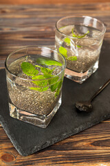 Healthy breakfast or morning with chia seeds and mint on table background, vegetarian food, diet and health concept. Chia pudding with and mint