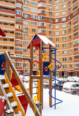 A new children's playground in the courtyard of a multi-storey residential building in winter. A new neighborhood. Moscow region. Prominent. Boulevard Green alleys.