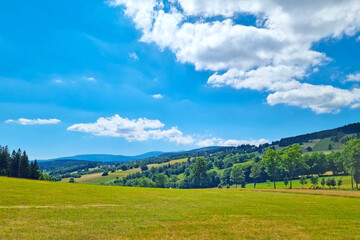 Beautiful mountain valley on a sunny summer day. Walking in the mountains. Green meadow. Nature background.