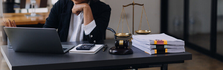 law books and scales of justice on desk in library of law firm. jurisprudence legal education...