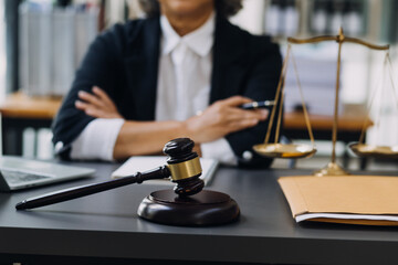 law books and scales of justice on desk in library of law firm. jurisprudence legal education concept.