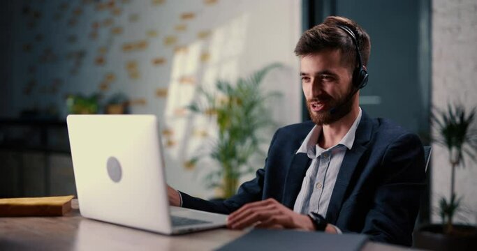 Male manager of online store is at business video meeting with representatives of another trading platform and agrees on cooperation. Young man with beard communicates in friendly way on a video call.