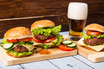 Burgers and beer on wooden background
