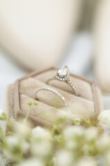 Bride diamond wedding ring and engagement band in a cream velvet ring box