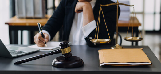 law books and scales of justice on desk in library of law firm. jurisprudence legal education concept.