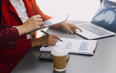 Businessman and team analyzing financial statement Finance task. with smart phone and laptop and...