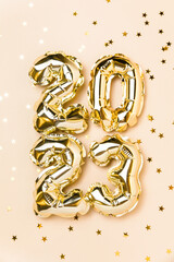 New year 2023 balloon celebration card. Gold foil helium balloon number 2023, party decoration,...