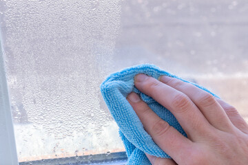 Condensation on windows in winter, wiping with a dry cloth