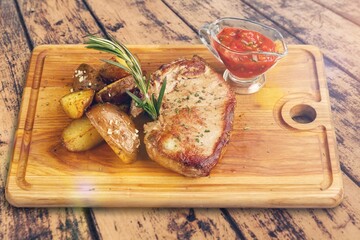 Grilled tasty meat dish on wooden board