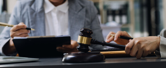 justice and law concept.Male judge in a courtroom on wooden table and Counselor or Male lawyer working in office. Legal law, advice and justice concept.