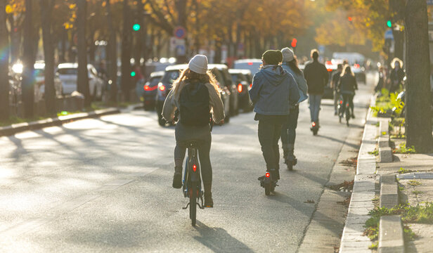 Des personnes en train de se d&eacute;placer en trottinette et en v&eacute;lo en ville.