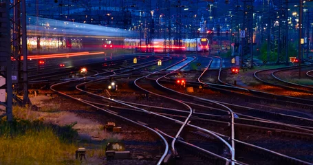Fototapete Rund Panorama at main station of Hagen in Westphalia Germany at blue hour twilight. Railway tracks with switches, lamp lights and blurred trains in motion. Colorful railway infrastructure and technology.  © ON-Photography