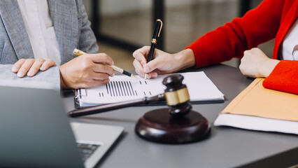 Business and lawyers discussing contract papers with brass scale on desk in office. Law, legal services, advice, justice and law concept picture with film grain effect