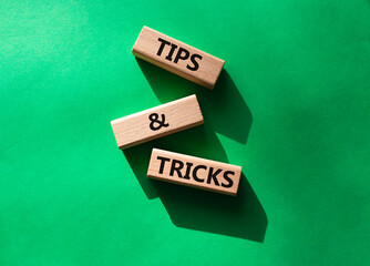 Tips and tricks symbol. Wooden blocks with words Tips and tricks. Beautiful green background. Business concept and Tips and tricks. Copy space.