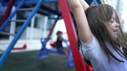 Small girl holding into metal bar at playground child hand holds on monkey bar © Marco