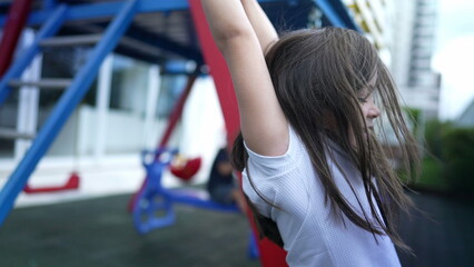 Small girl holding into metal bar at playground child hand holds on monkey bar