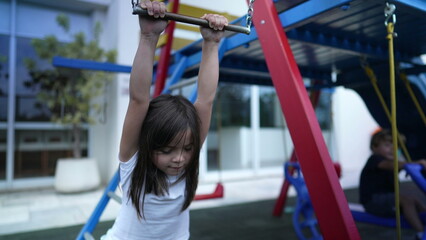 Small girl holding into metal bar at playground child hand holds on monkey bar