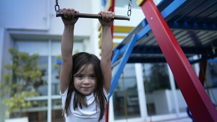 Small girl holding into metal bar at playground child hand holds on monkey bar