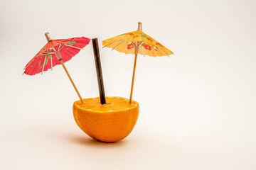 pair of colorful orange  and red party drinks parasol umberellas and black bamboo straw in half an...