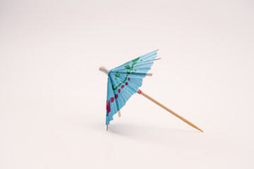 Single blue cocktail parasol umbrella isolated on a white background side view - obrazy, fototapety, plakaty