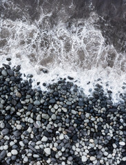 Obraz premium Drohnenaufnahme,Meeresbrandung mit großen runden Steinen am Strand von Rocha da Relva,Insel Sao Miguel,Azoren,Portugal,