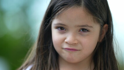 Cute little girl portrait pensive child closeup standing outside