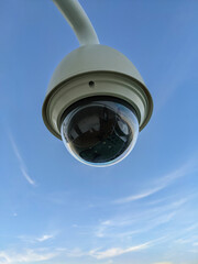 Blick auf eine moderne Sicherheitskamera oder Überwachungskamera in einem Außenbereich vor blauem Himmel mit viel Textfreiraum