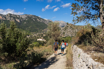 Obraz premium hikers coming to town, Orient valley , Bunyola, Majorca, Balearic Islands, Spain