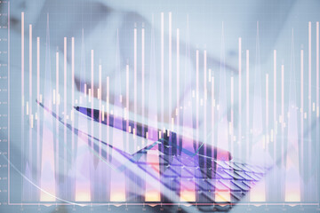 Stock market graph on background with desk and personal computer. Double exposure. Concept of financial analysis.