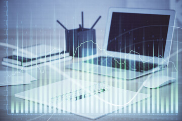 Stock market graph on background with desk and personal computer. Double exposure. Concept of financial analysis.
