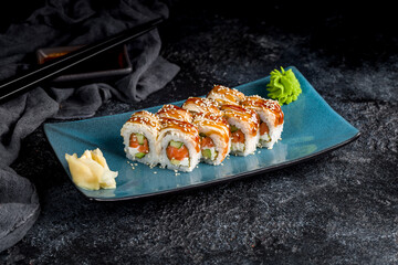 roll Canada with eel and salmon on plate on dark table