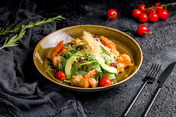 salad with shrimp, avocado, tomatoes and parmesan on dark table