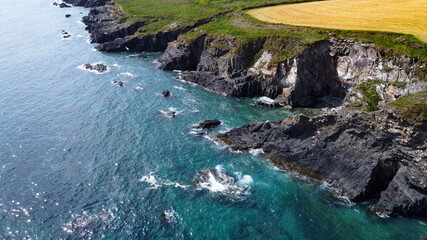 Fototapeta na wymiar Seaside landscape of the south of Ireland. Picturesque coastal cliffs. The water of the Atlantic Ocean is turquoise.