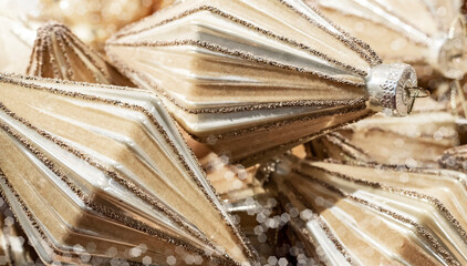 Background of Christmas tree decorations close up. Embossed geometric vintage Christmas tree ornaments in soft beige colors.