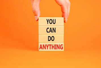 You can do anything symbol. Concept word You can do anything on wooden blocks. Businessman hand. Beautiful orange table orange background. Business and you can do anything concept. Copy space.