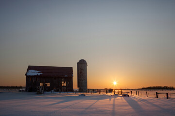 Dilapidated barn at sunrise in winter; Rudyard, Michigan, United States of America