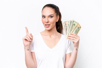 Young caucasian woman taking a lot of money isolated on white background thinking an idea pointing the finger up