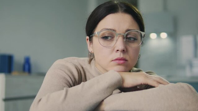 Upset frustrated young brunette woman leaning head on hands and contemplating, remembering past relationship and dreaming about unrealizable future, procrastination mood