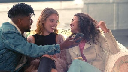 Group of friends, party and smartphone for social media, connectivity and communication. Young people, smile and phone for posting, share pictures and enjoy festival for weekend break and event. - Powered by Adobe