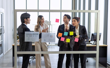 Employee meeting at office and use post it notes to share idea brainstorming stick on glass wall