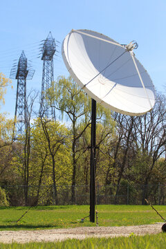 Satellite dish with electrical power transmission towers in the background