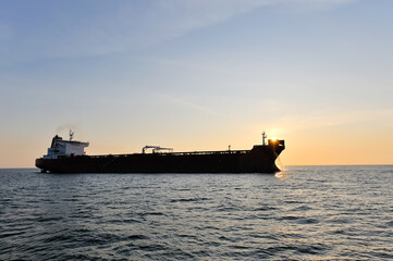 Crude oil tanker in the sea at sunset.