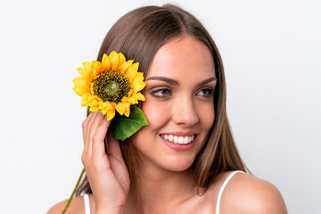 Young caucasian woman isolated on white background holding a sunflower while smiling. Close up portrait