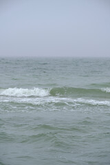 Undulating Baltic Sea in autumn foggy weather.