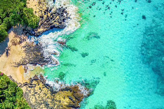 View From Directly Above Of The Shoreline And Surf With Turquoise Waters And Palm Trees On The Beach Of The Tropical Island Of Maui, Hawaii, USA; Maui, Hawaii, United States Of America