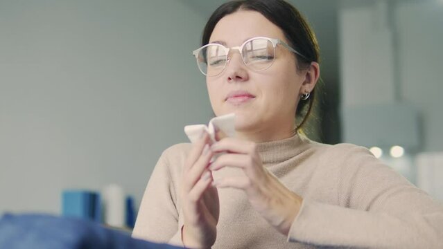 Young woman wiping nose with napkin, sneezing, cached seasonal cold or allergy