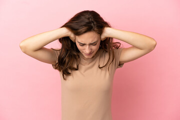 Fototapeta premium Young caucasian woman isolated on pink background frustrated and covering ears