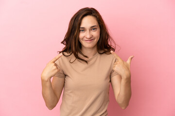 Fototapeta premium Young caucasian woman isolated on pink background giving a thumbs up gesture