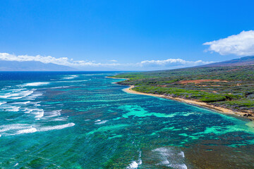 Aerial view of the coast of Shipwreck Beach in Lanai with turquoise water and ocean waves rolling into the shore; Lanai, Hawaii, United States of America