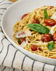 Spaghetti with cherry tomatoes, basil, and shaved parmesan.